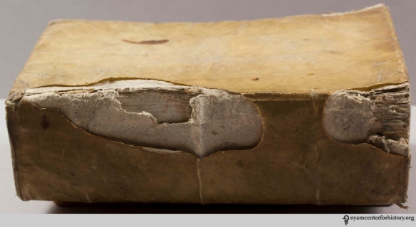 Wrapped board binding with inner paper board stiffener visible through damaged outer parchment cover. Lyon, 1641
